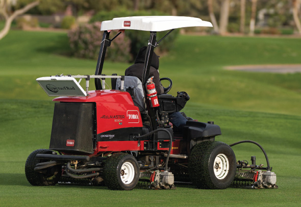 Someone using a commercial Toro mower on a golf course with Turf Rad equipment attached to it.